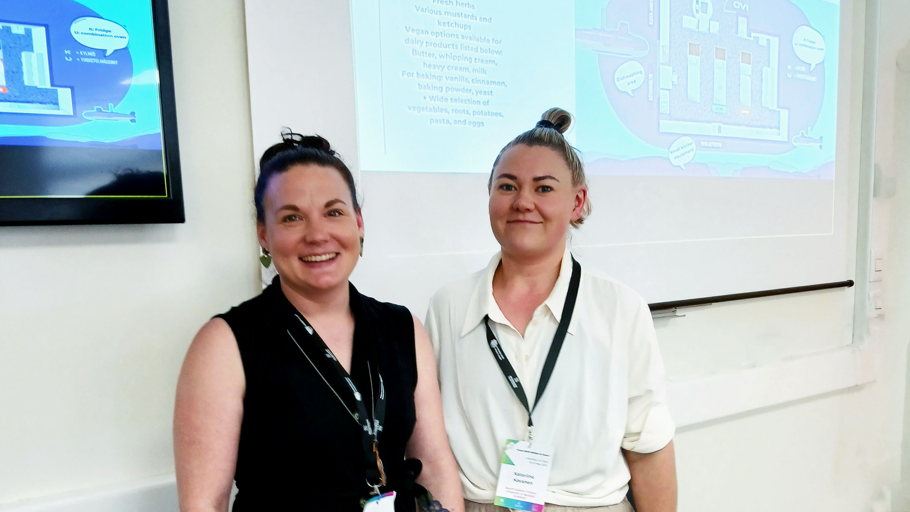 Laura and Katariina smiling in front of their presentation.