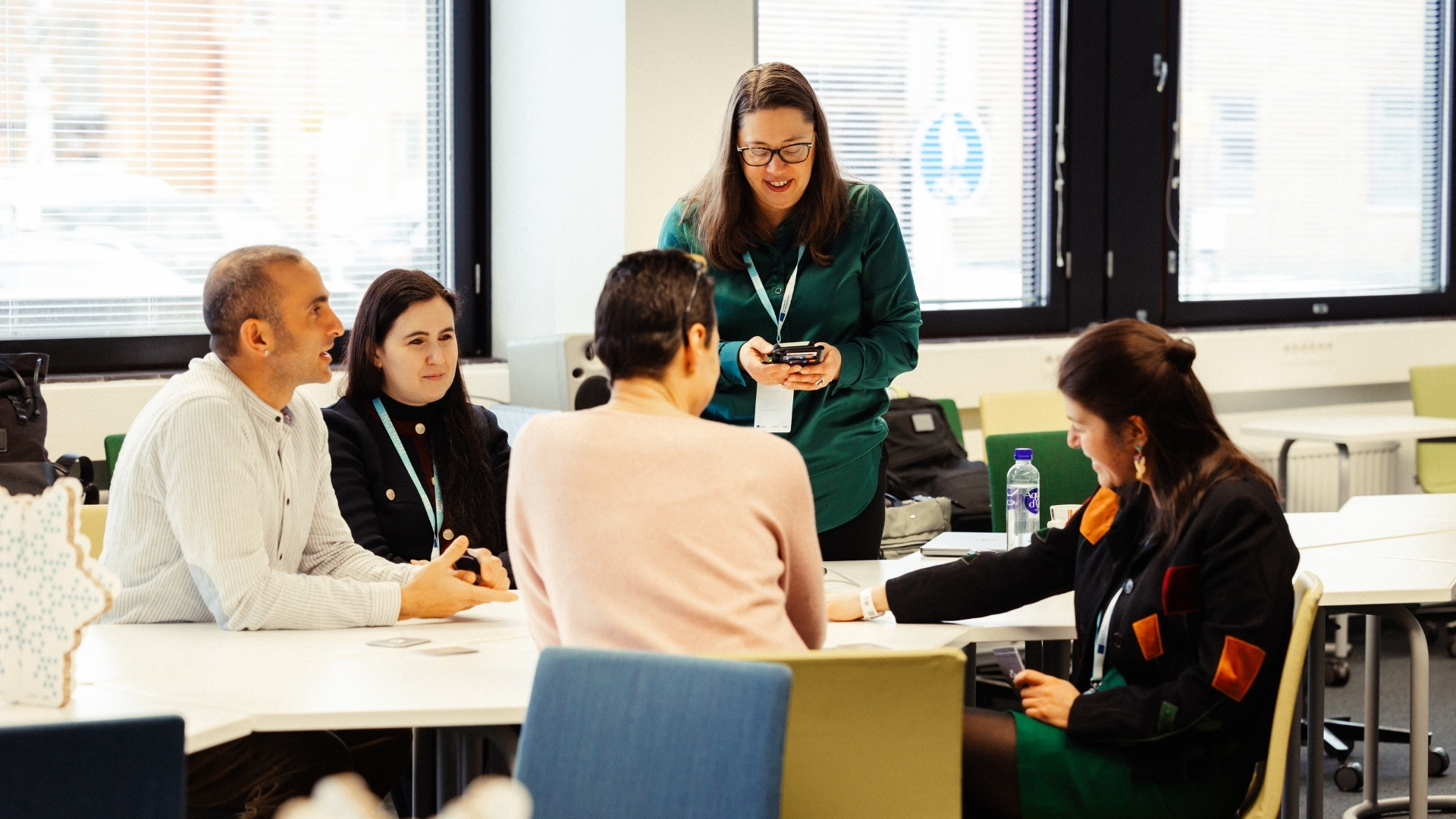Five persons discussing around a table